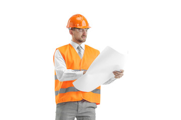 The builder in a construction vest and orange helmet standing on white studio background. Safety specialist, engineer, industry, architecture, manager, occupation, businessman, job concept