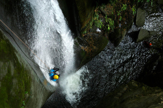 Woman rappeling waterfall