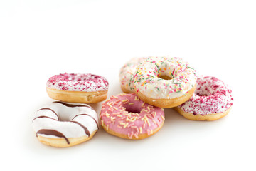 sweet food, junk-food and unhealthy eating concept - close up of glazed donuts on white table