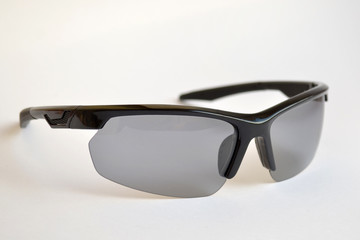 Sport black sunglasses with photochromic and polarizing effect on white background