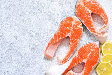 Fresh, raw salmon with lemon on a white concrete background. View from above.