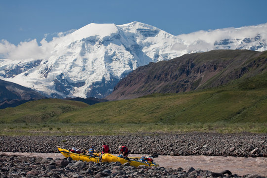 Gaia Thurston-Shaine, Michael Behar, Fred Dure rigging for a raft trip near the headwaters of the Jacksina river with Mt Jarvis behind, Wrangell-St. Elias National Park, Alaska.