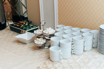 set of white cups on a white tablecloth 1