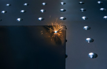 Closeup laser engraver working and engraving flat metal surface