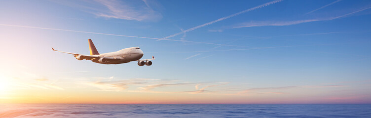 Fototapeta na wymiar Commercial airplane flying over dramatic sunset
