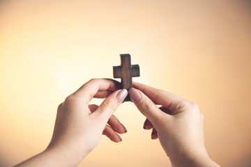 woman hand holding wooden cross
