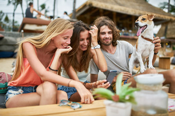 three russian tourists with pet dog having fun at beach side resort on koh samui thailand