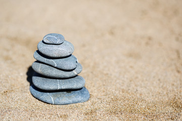 Fototapeta na wymiar Zen stones balance on the sand beach, close up