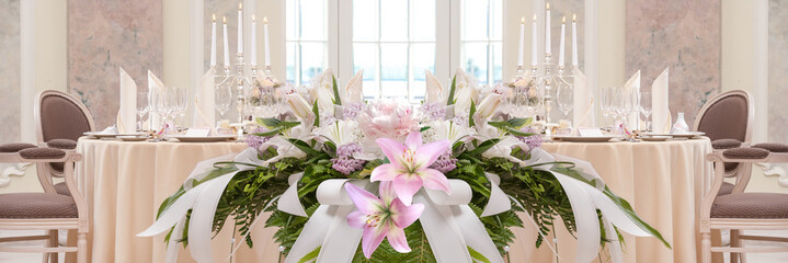 Festive covering table with candles and flowers in the foreground