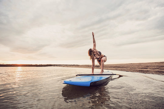 Woman Doing Yoga On Paddleboard