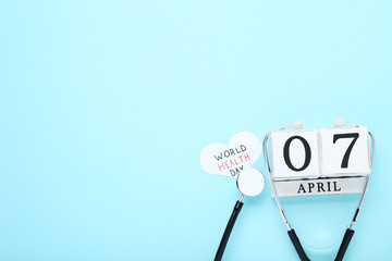 Text World Health Day with stethoscope and cube calendar on blue background