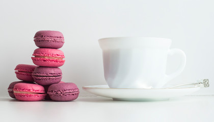 afternoon tea table with colorful macarons and a tea cup