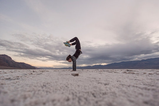 Woman doing a handstand on the salt flat