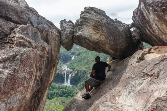 Hiker sitting on rock formation, Mirante da Janela, Chapada dos Veadeiros, Goias, Brazil