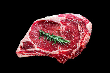 Beef steak bone in with rosemaryand salt isolated on black background