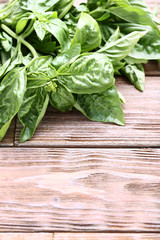 Green basil leafs on brown wooden table
