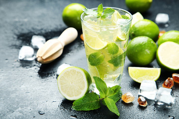 Mojito cocktail in glass with sugar on wooden table