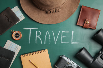 Flat lay composition with different tourist objects and word TRAVEL on color background