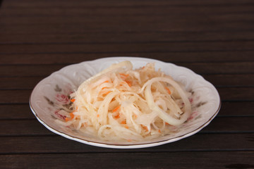 Sauerkraut in a plate on a dark table