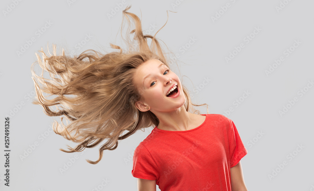 Wall mural people concept - smiling teenage girl in red t-shirt with long hair waving over grey background