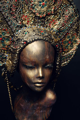 Head of mannequin in decorated bronze kokoshnick, dark studio background