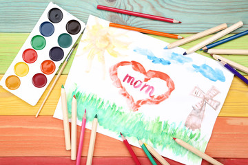 Greeting card for Mothers Day with paints and pencils on wooden table