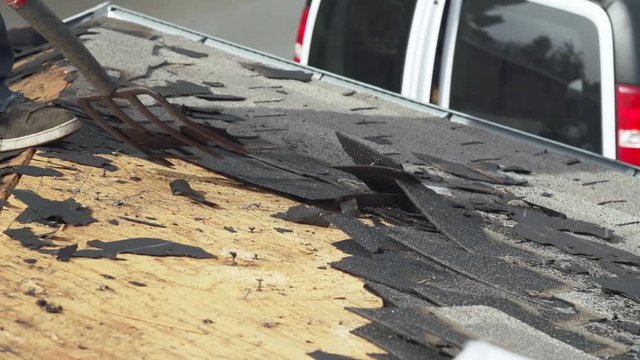 Asphalt roof shingle removal during residential reroofing at house