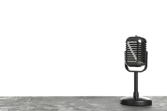 Retro microphone on table against white background. Space for text