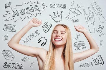 DJ party. Happy young blonde woman with naked shoulders smiling with raised hands while standing against grey background with music theme doodles