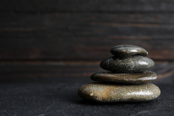 Stack of zen stones on table against blurred background. Space for text