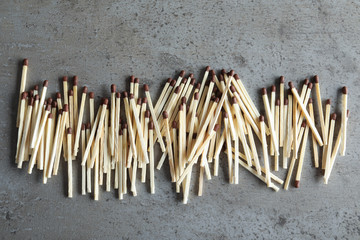 Many matches on grey background, top view