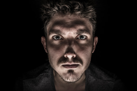 Portrait of serious young man Isolated on black background
