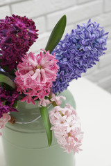 Beautiful hyacinths in metal can on table, closeup. Spring flowers