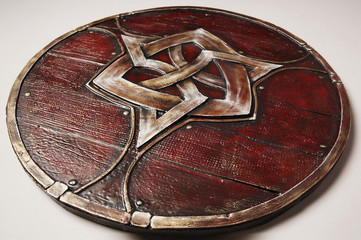 Closeup of vintage wooden shield with emblem, isolated on white background