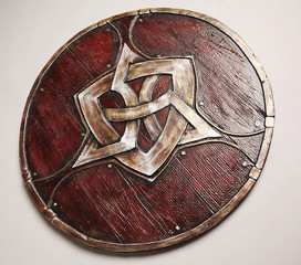 Closeup of vintage wooden shield with emblem, isolated on white background