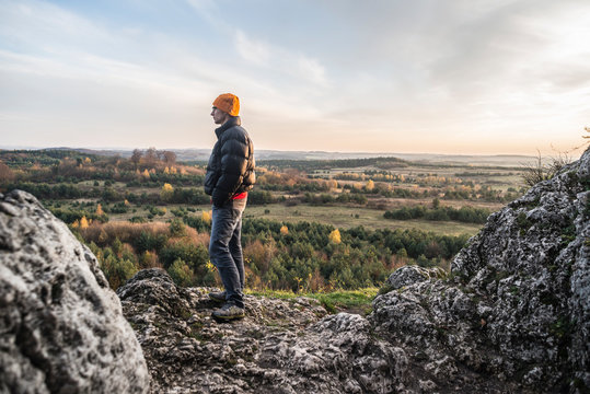 Man standing on rock formation and looking at view, Polish Jura, Rzedkowice, Silesia, Poland