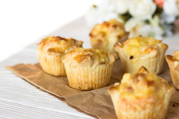 Mini savory pie with chicken, leek, cheese on light background, top view. Delicious appetizer, snack, breakfast, tapas