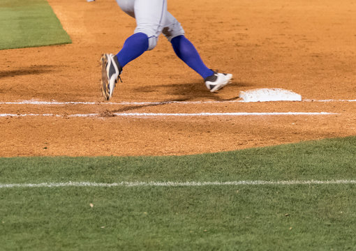 Low section of a baseball player rounding first base