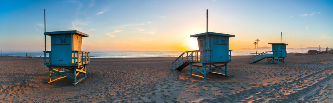 Deserted lifeguard stands on beach during sunset