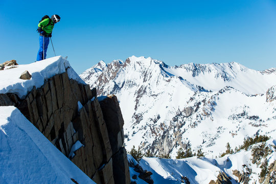 Man Looking Down Cliff While Skiing, Wasatch Mountains, Utah, USA