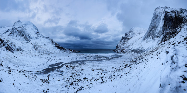 View of snow covered Bunes Beach against storm clouds