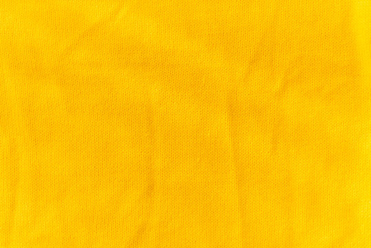 Yellow crocheted fabric texture. Material is crumped a little