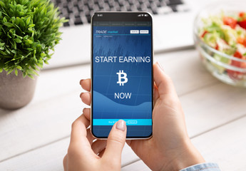Woman using bitcoin earning application on smartphone