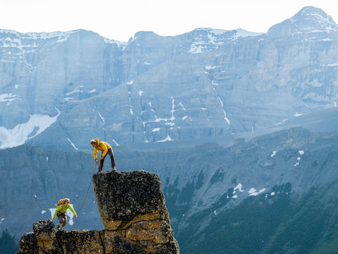 Mountaineering couple ascend rock pinnacle, mountains