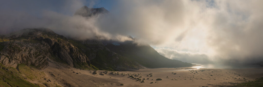 Storskiva peak behind fog and Bunes beach, Moskenesoya, Lofoten Islands, Norway