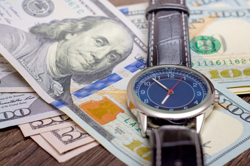 The watch is lying on dollars. Time to earn money. Time is money_
