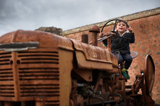 Boy sitting on old tractor