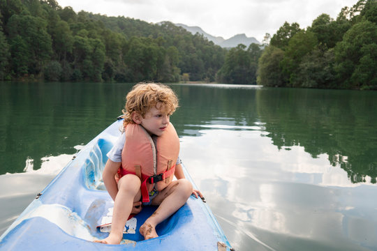 A two years old boy sitting on a kayak at Rancho Santa Elena, Hidalgo, Mexico,