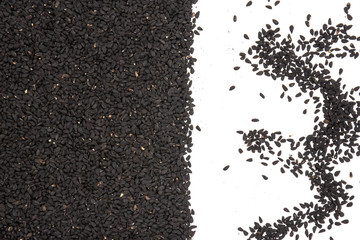 Lot of whole small black cumin seeds flatlay isolated on white background