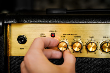 Guitar electric amplifier. Hand turning volume control knob up to the max. Rock music overdrive...